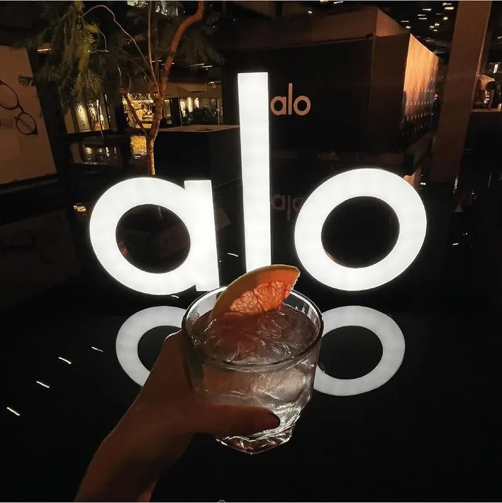 Brindis frente al letrero iluminado de ALO en su apertura en Querétaro