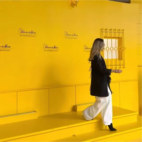 Creadora de contenido frente a una pared amarilla en una apertura
