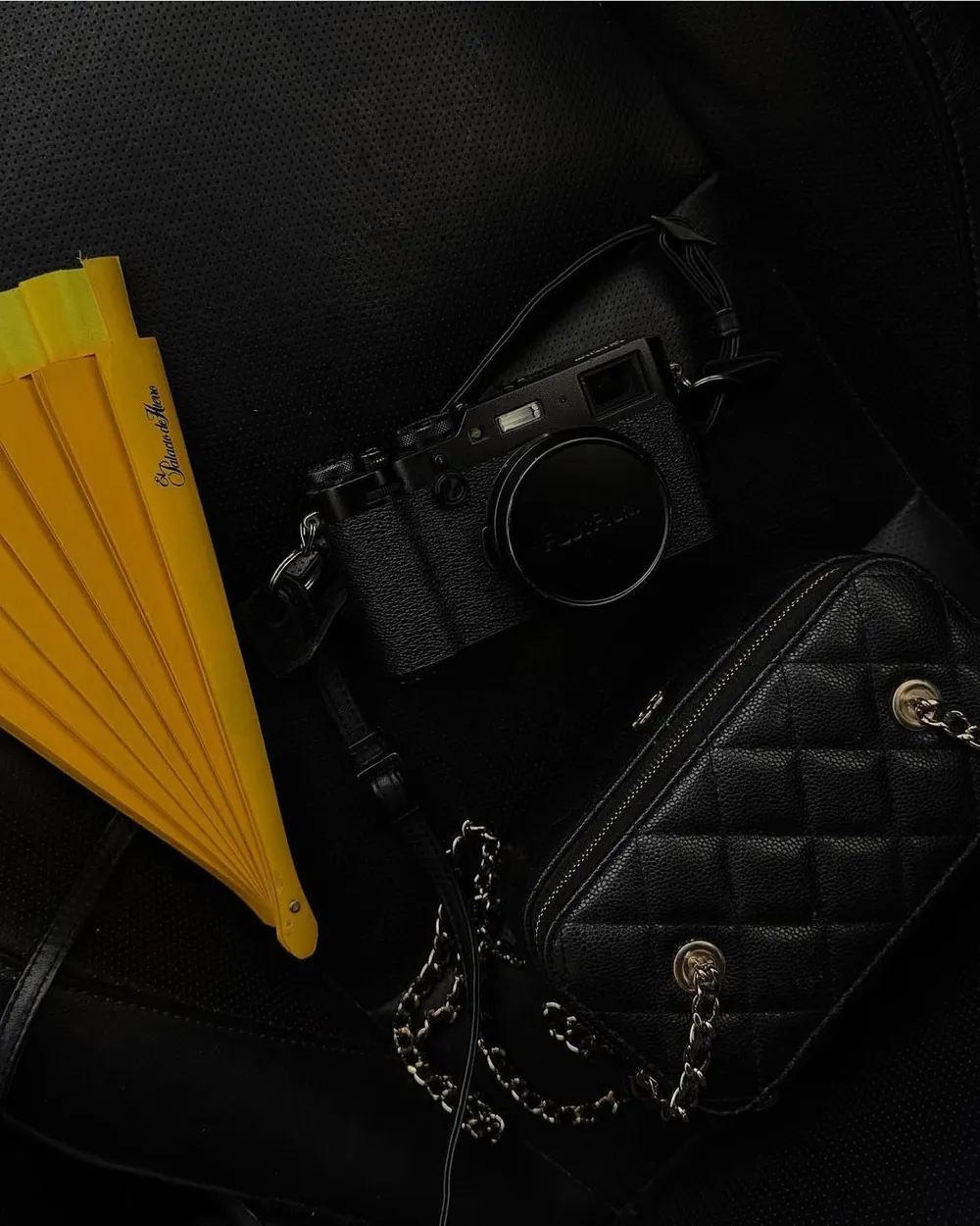 Cámara, bolsa negra y abanico amarillo para una sesión de contenido